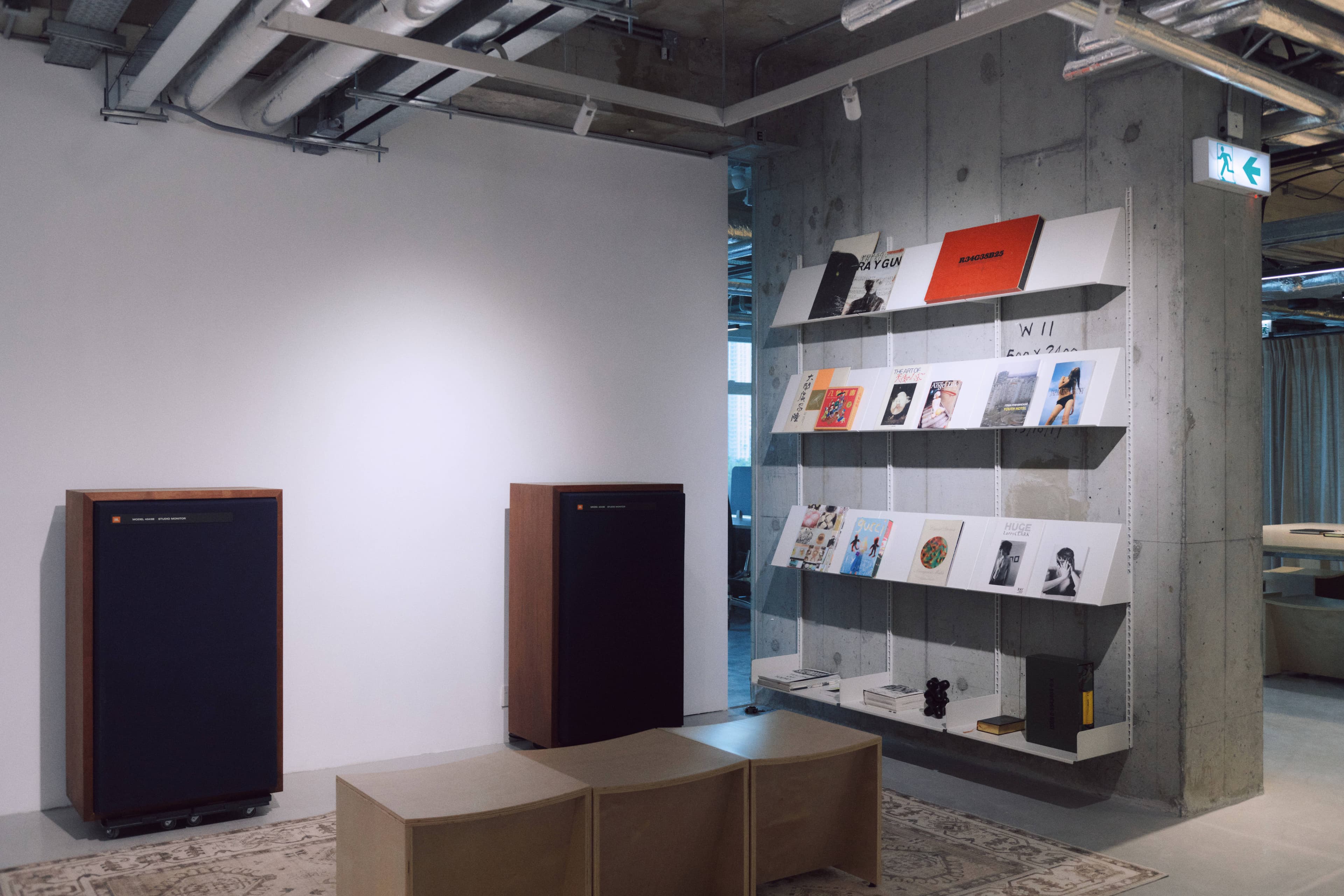 Library archive with shelves of art volumes and a screening wall